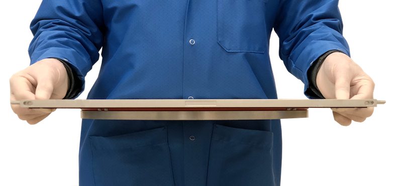 An engineer holding a WaferPak full-wafer contactor, a thin round-cornered plate the size of a wafer